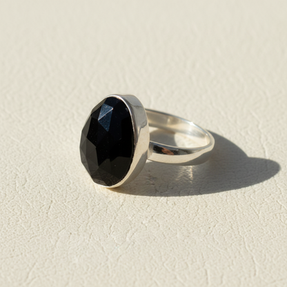 Silver ring with oval black faceted gemstone center