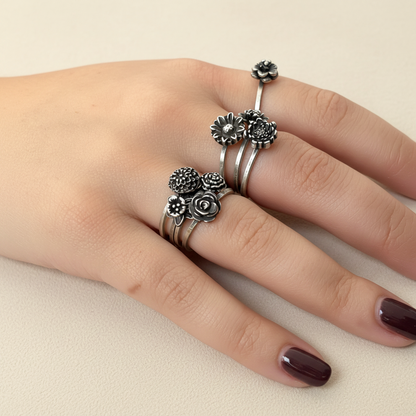 Silver floral ring on a hand with a white background
