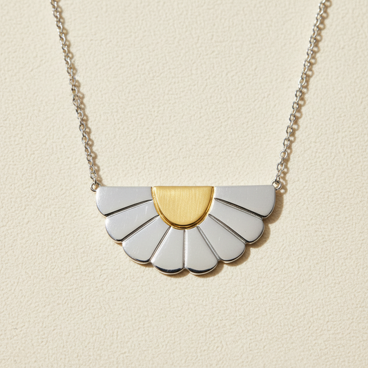 Necklace with a gold and silver pendant on a white background