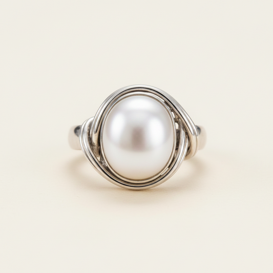 Sterling silver ring with oval white pearl encircled by three curved wire bands, size 8.5