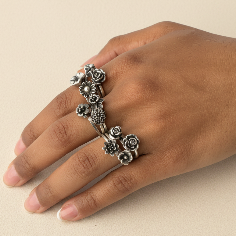 Hand wearing a decorative silver ring on a white background