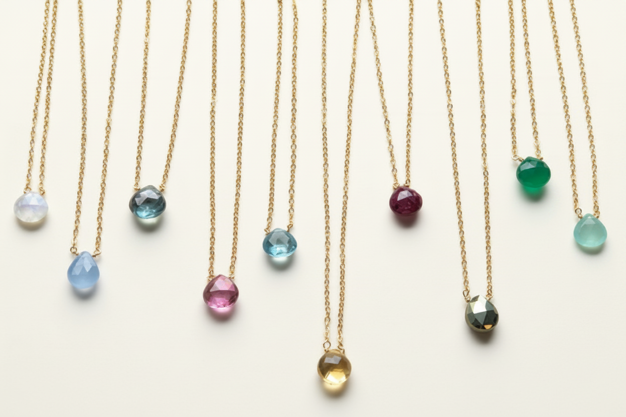 Dainty gold-tone chain necklace with faceted teardrop gemstone pendants, including amethyst