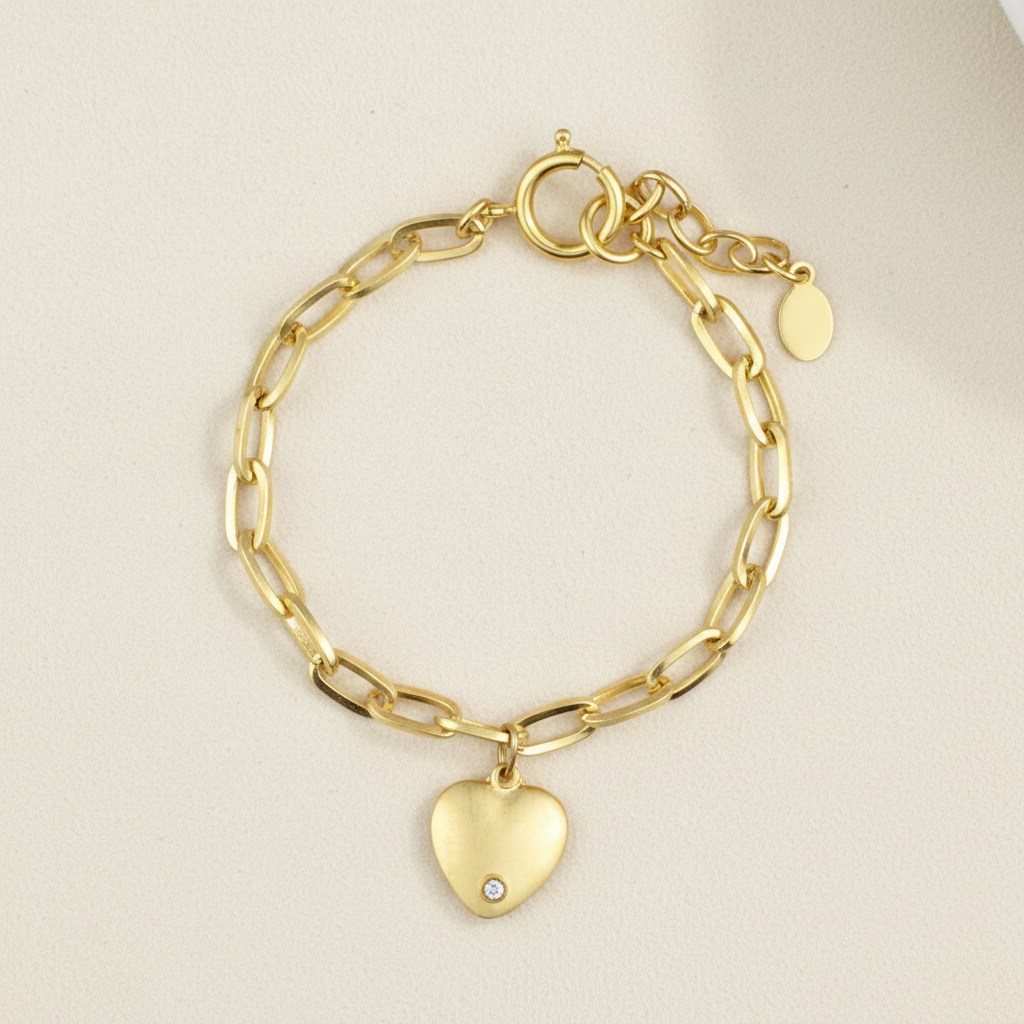 Gold-tone chain bracelet with heart charm and small round tag charm
