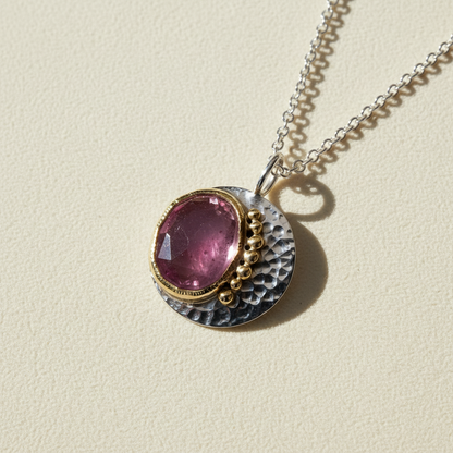 Round pendant necklace with pink gemstone, gold bezel, textured silver reverse