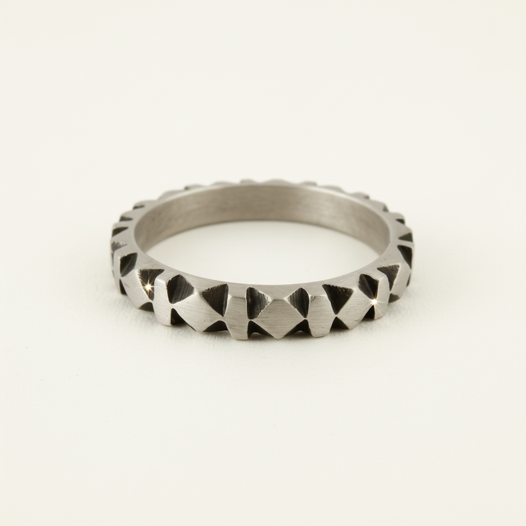 Silver-tone hand-carved band ring with raised diamond-cut pattern across the band