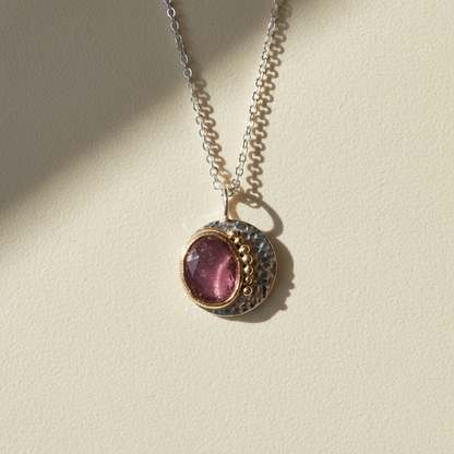 Round pink gemstone pendant necklace with hammered two-tone metal and silver chain