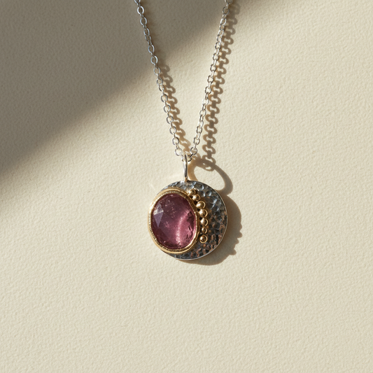 Round pink gemstone pendant necklace with hammered two-tone metal and silver chain