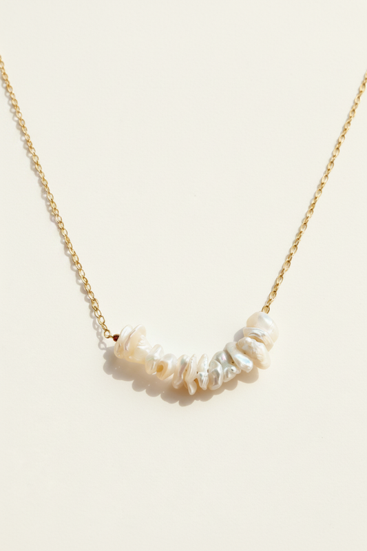 Keishi pearl row necklace, gold chain with white irregular pearls along curve