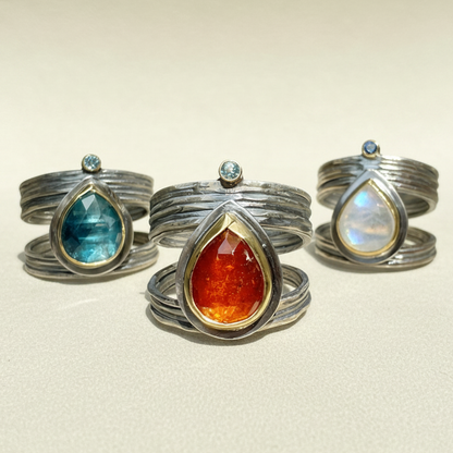 Set of three silver-tone rings with teardrop gemstones and small round accents