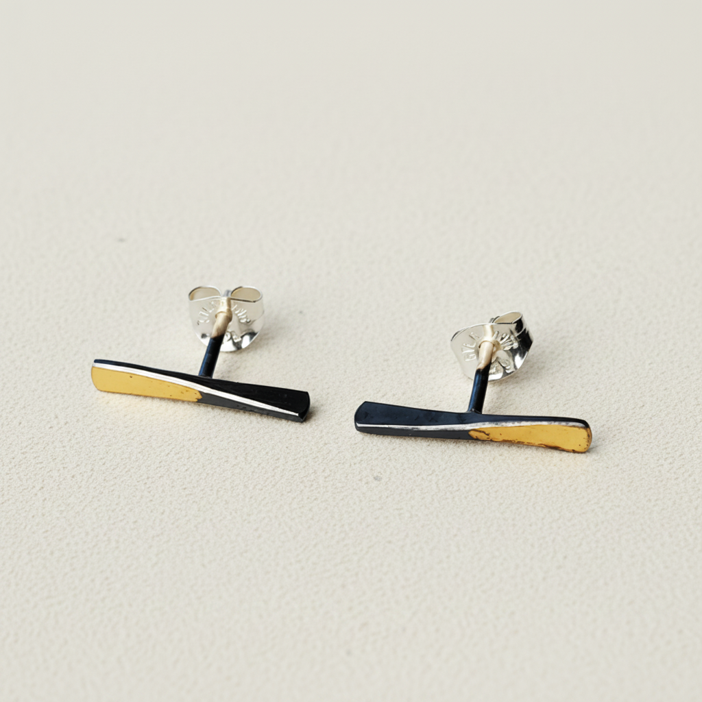 Bar stud earrings with black enamel and gold edge stripes, silver-tone backs