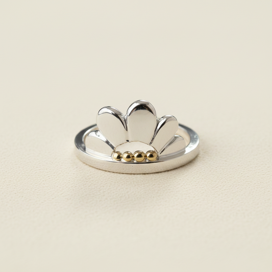 Flower-shaped silver ring with white petal tips and gold bead detail on band