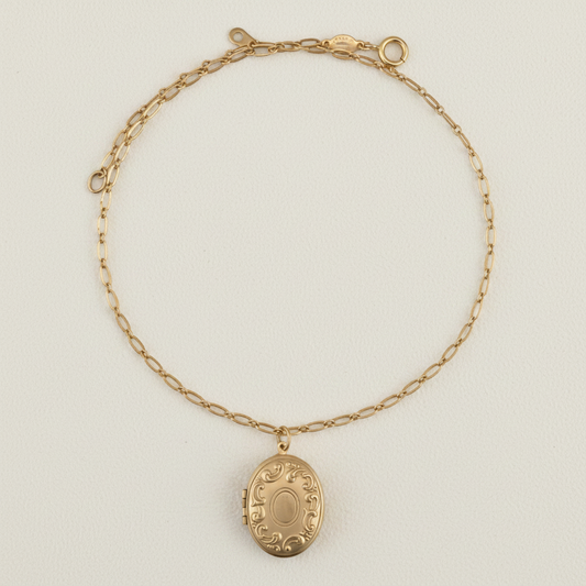 Gold-tone locket necklace with oval pendant and linked chain collar