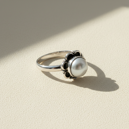 Round pearl ring with white pearl center and dark twisted prong accents
