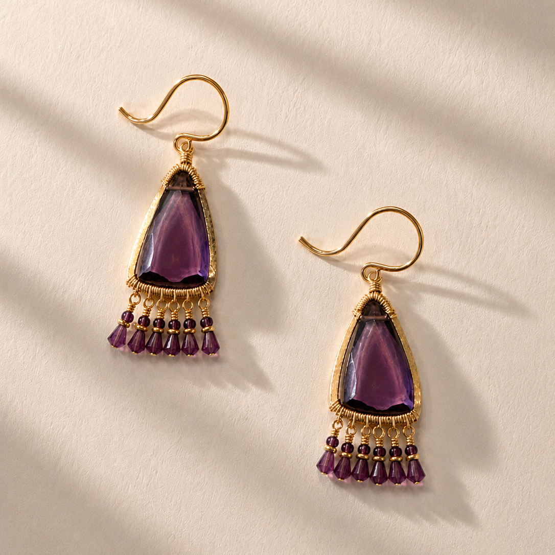 Jasmine earrings with gold-tone hooks, purple teardrop centerpiece, and dangling purple bead tassel