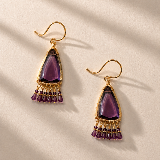 Jasmine earrings with gold-tone hooks, purple teardrop centerpiece, and dangling purple bead tassel