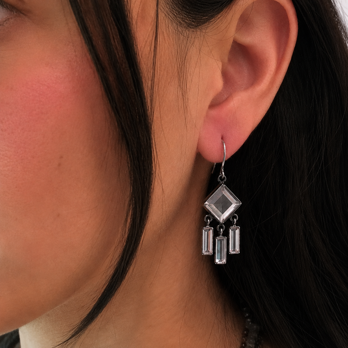 Clear quartz chandelier earrings on ear: square charm with three rectangular clear stones