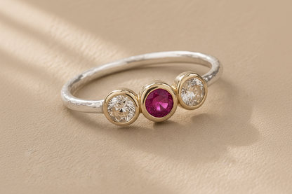 Silver ring with gold bezel set pink ruby and two side round clear stones