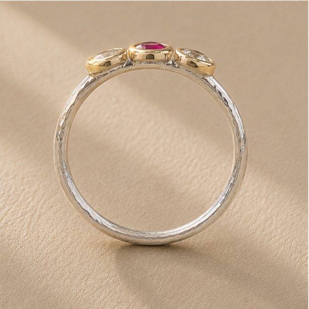 Silver circular band with raised edge detail and small pink stone under top bezel