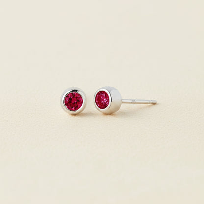 Tiny birthstone stud earrings with round red ruby CZ in silver-tone settings
