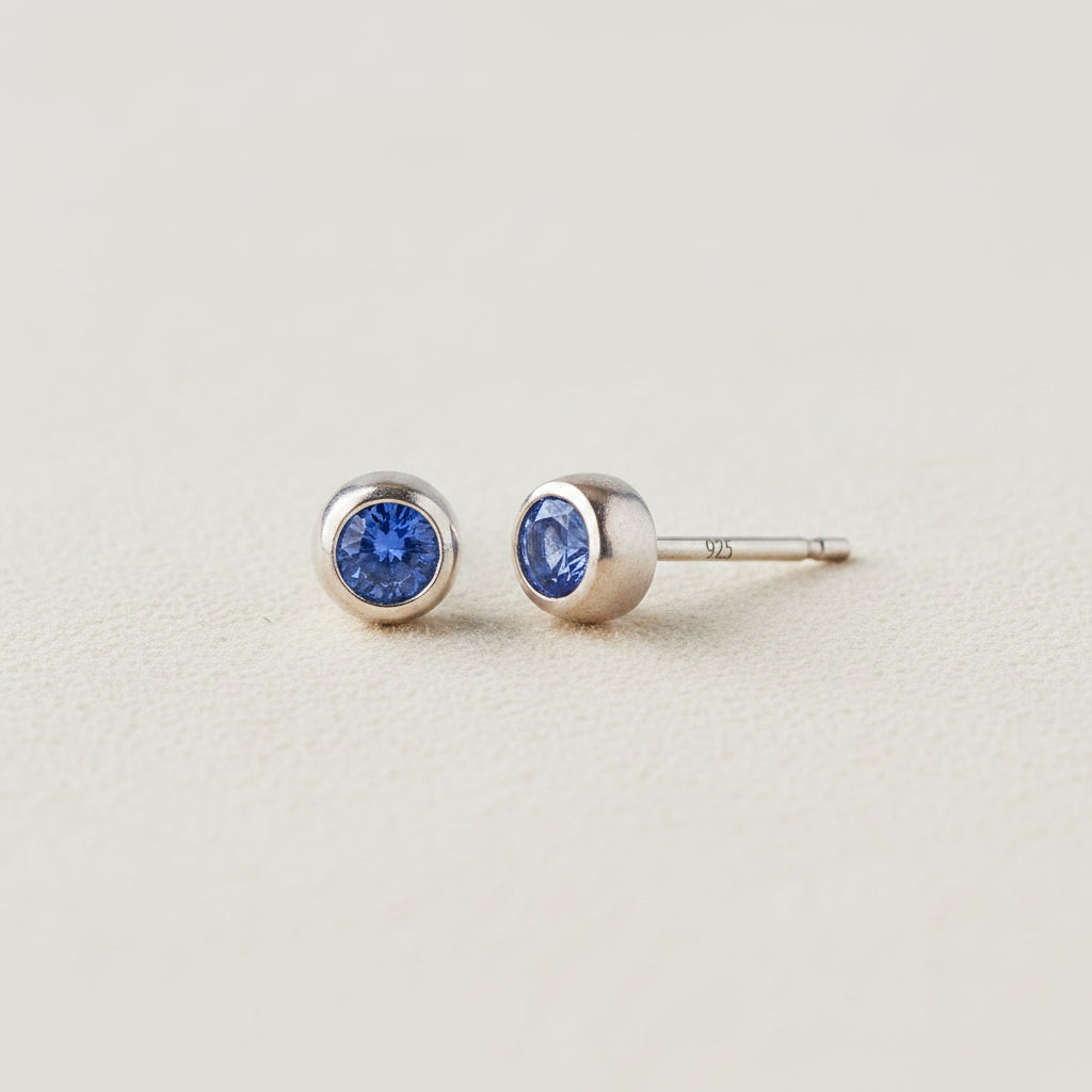 Tiny birthstone stud earrings with round blue sapphire CZ in silver-tone settings