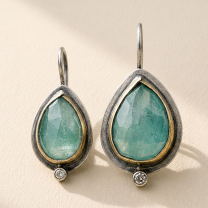 Teardrop rim earrings with green gemstone teardrops, gold-tone edges, and crystal accents