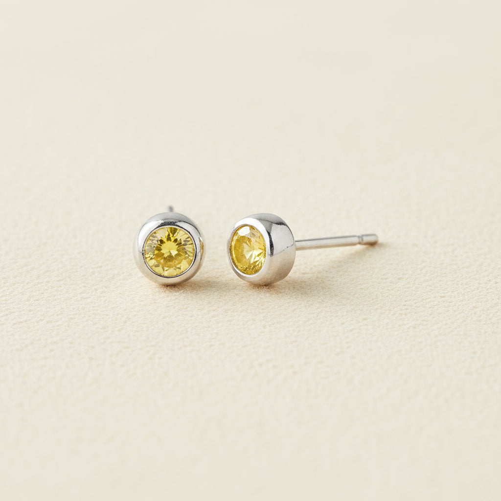 Tiny birthstone stud earrings with round yellow CZ in silver-tone settings